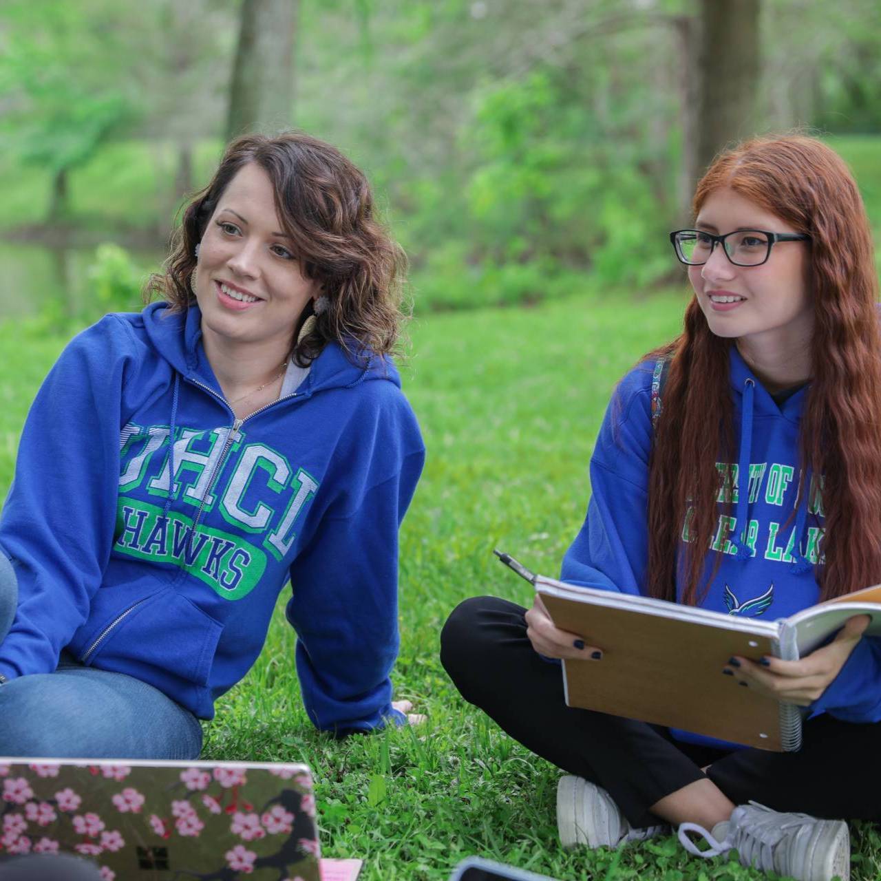 UHCL students studing in a group outside on the grass.