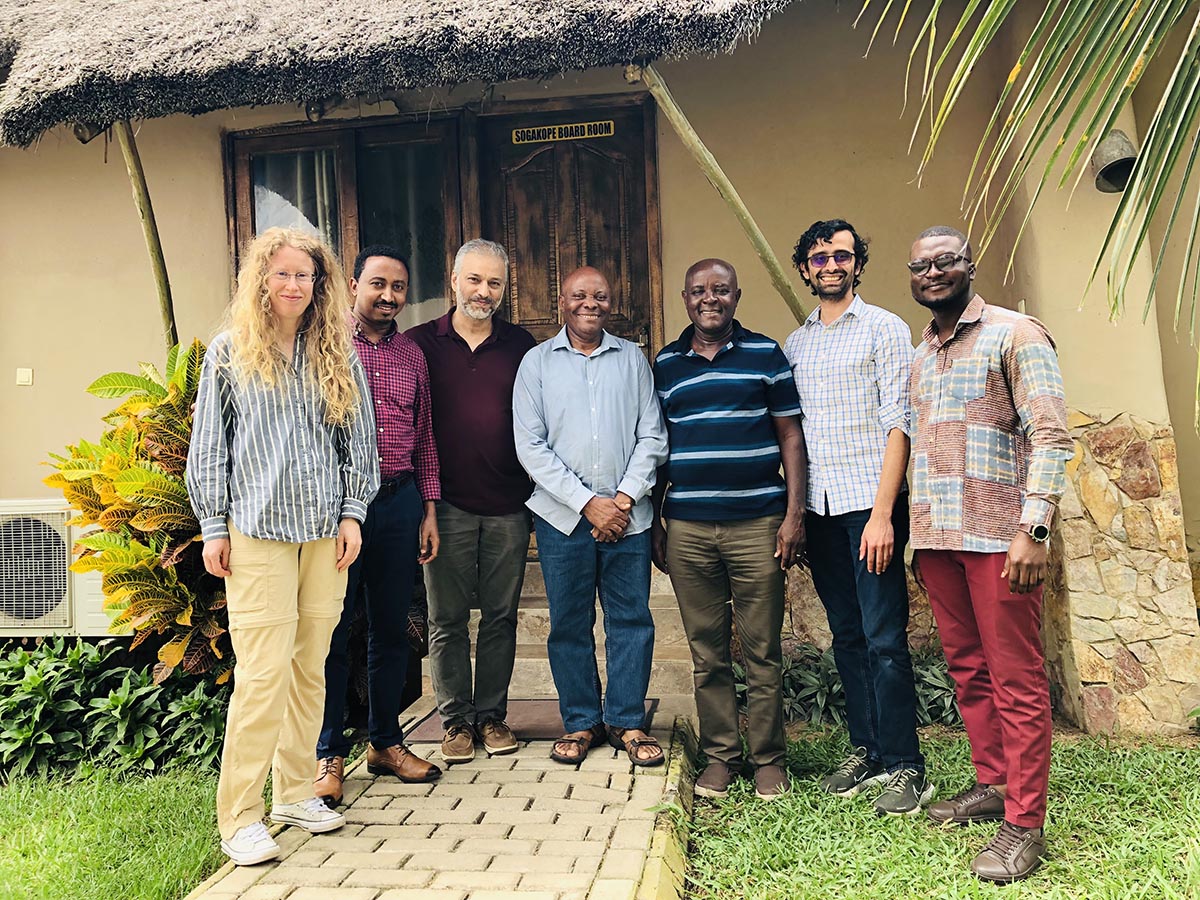 Seven people pose for a photo outside the Sogakope Board Room