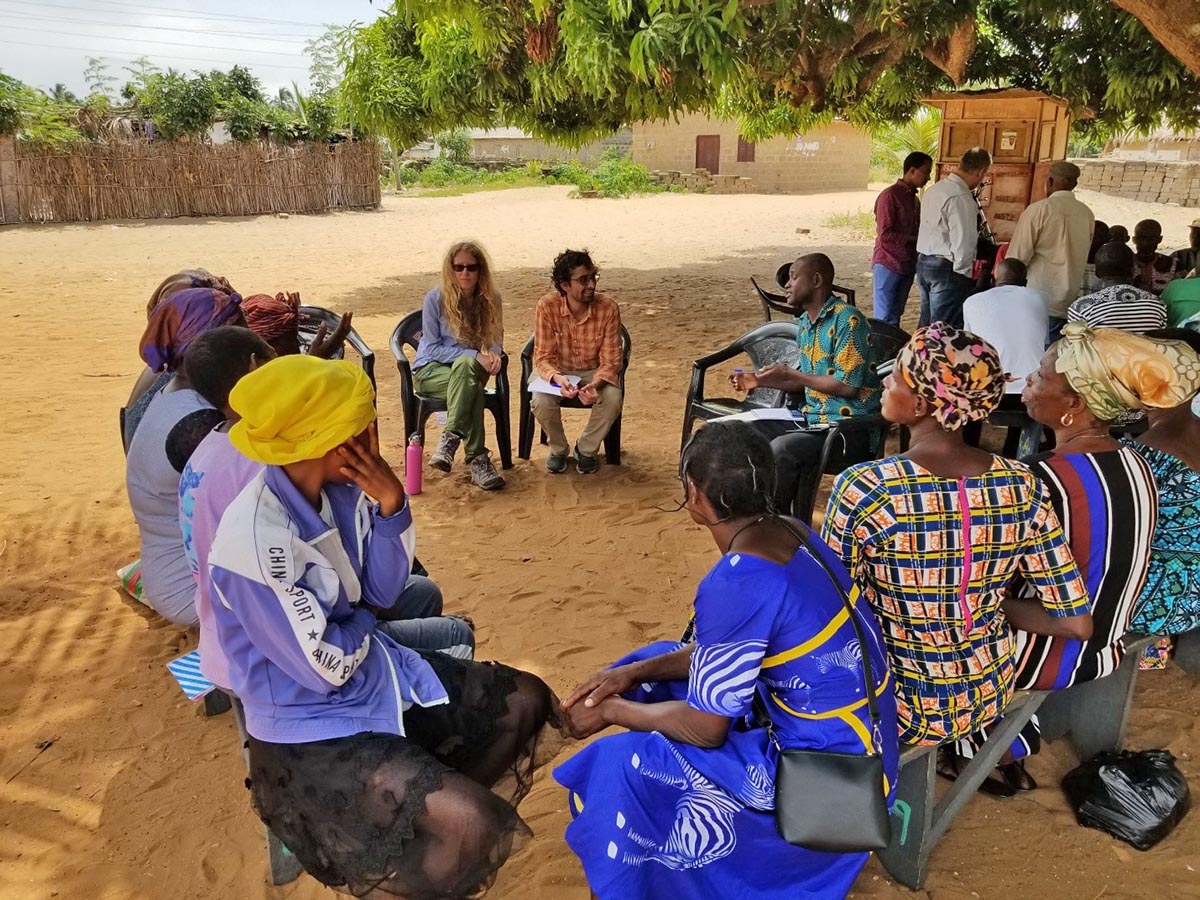 group of people sitting in a circle under a tree