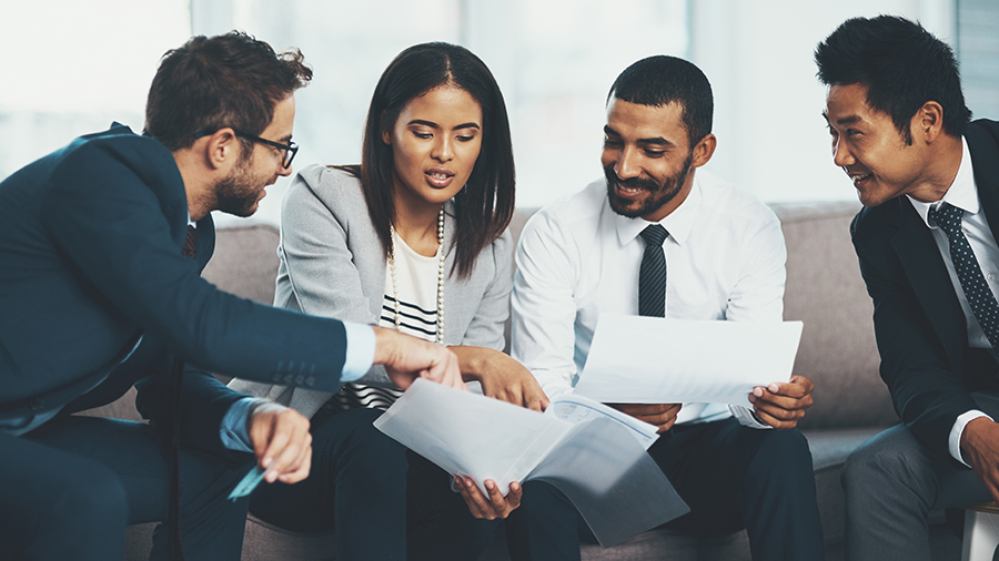 Four people reviewing data in a conference room