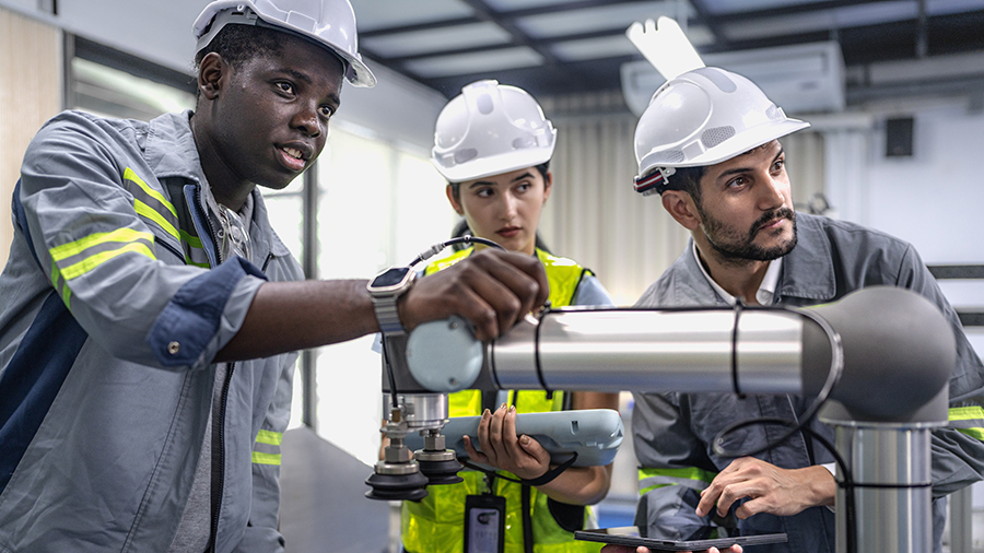 Photo of three people in the engineering field within warehouse