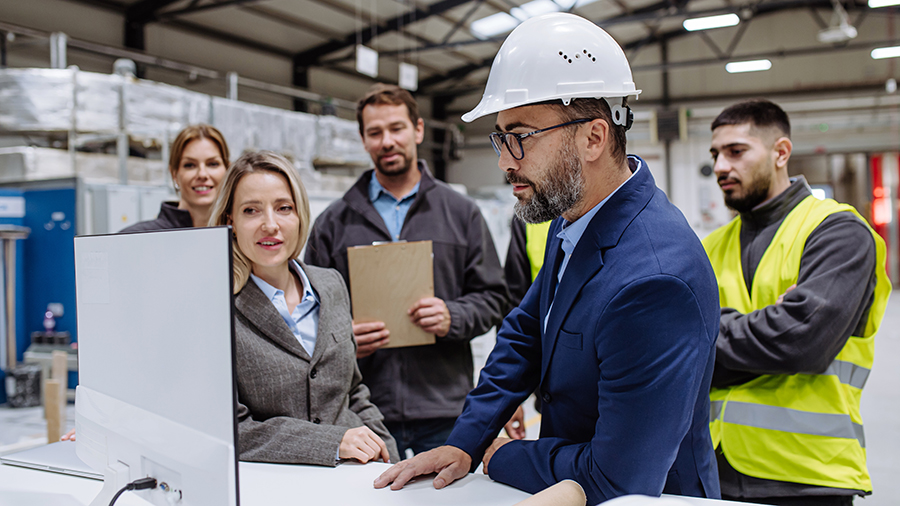 Photo of a group of people huddled in a warehouse around a monitor