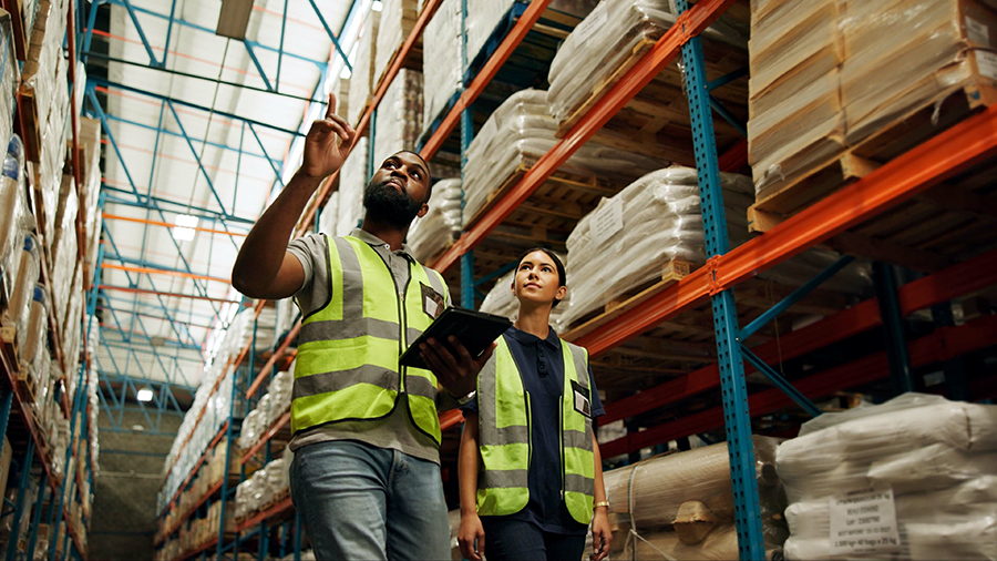 Two people walking through warehouse aisles